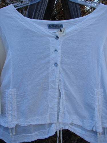 Barclay NWT Cotton Sleeved Crop Drawcord Top on a hanger, featuring a three-button front, wide V neckline, and three-quarter length sleeves with pull cord accents.