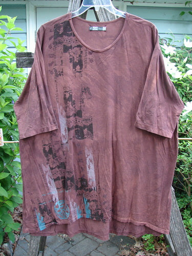 Barclay Tournesol Tunic Side Garden Mottled Burgundy OSFA features a tunic-length design with drop shoulders, loose three-quarter sleeves, and a rounded neckline, showcasing a village-themed print on a mottled backdrop.