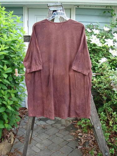 Barclay Tournesol Tunic Side Garden Mottled Burgundy OSFA features a tunic length, drop shoulders, loose three-quarter sleeves, and a rounded neckline, showcasing a side garden and tiny village theme.