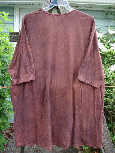 Barclay Tournesol Tunic Side Garden Mottled Burgundy OSFA features a tunic length, drop shoulders, loose three-quarter sleeves, and a unique hemline with painted garden and village motifs.