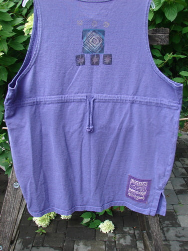 1996 Symbol Vest Star Rain Byzantium Size 2: Purple sleeveless cotton vest with rear drawstring and concentric diamond design on upper back, hanging on a wooden bench, showcasing Blue Fish's creative vintage style.