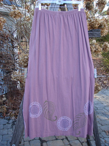 1996 Boulevard Festival Duo Laurel Size 1: A purple skirt with festival-themed designs on organic cotton fabric, paired with a matching jacket featuring interesting button accents and a varying shirttail hemline.