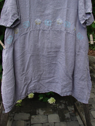 1997 Urchin Dress Sun Ray Swirl Sea Urchin Size 2: Loose-fitting, short-sleeved linen tunic with hand-painted spiral motifs, hanging outdoors, showcasing deep inseam side pockets and varying paneled hemline.