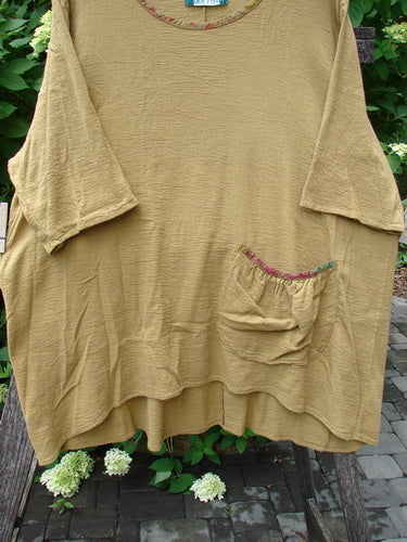 Barclay Gauze Round Bottom Tie Back Pocket Top Ditsy Daisy Golden Size 2 features a loose fit with a crinkled texture, three-quarter sleeves, asymmetrical hem, and a multicolored trim-edged pocket.