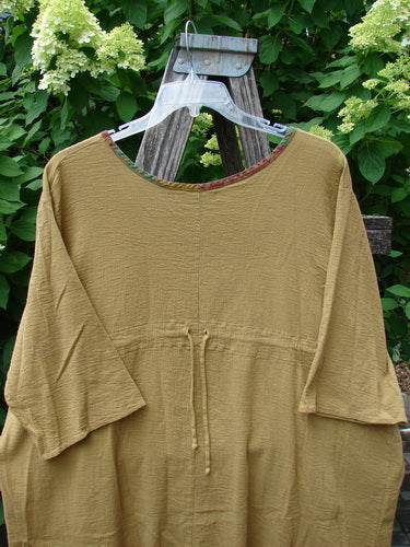 Barclay Gauze Round Bottom Tie Back Pocket Top Ditsy Daisy Golden Size 2: A loose-fitting, long-sleeved tunic with a round neckline and waist tie, crafted from lightweight, textured fabric, ideal for expressing individual style.