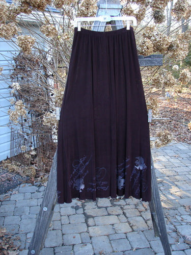 Streamer Vest and Moonbeam Skirt Duo from 1999; long black skirt displayed on a wooden rack, featuring a full elastic waistline, A-line shape, and lettuce edging suitable for fancy occasions.