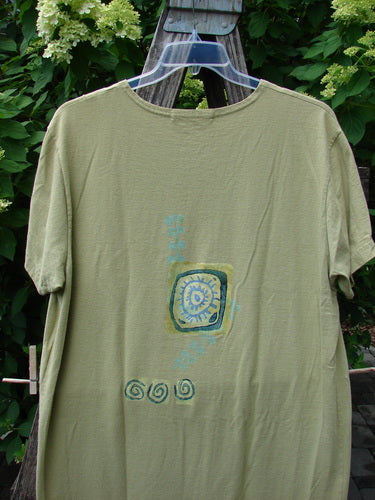 1997 Aquavella Dress Modern Gal Pear Size 1 displayed on a hanger outdoors. Features a stylized sun-like motif with abstract accents on the back, embodying vintage Blue Fish Clothing's creative and expressive style.