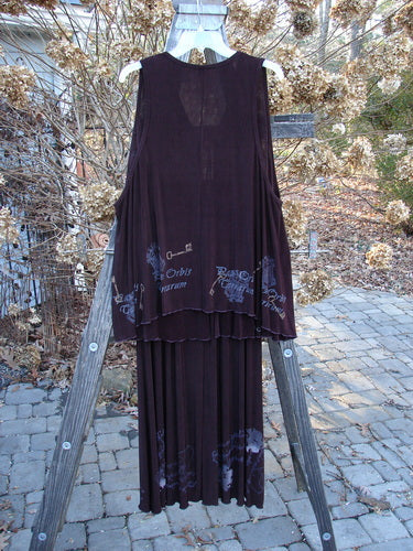 1999 Acetate Streamer Moonbeam Duo Key Deep Burgundy Size 1: a long dress on a rack with a flowing A-line shape and intricate Celtic key paint, featuring a silk tie closure and lettuce edging.