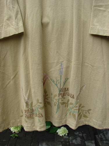 1998 Botanicals Bell Flower Top Iris Pseudacorus Seed Size 2 features a khaki-colored design with a muted botanical print along the hem, showcasing Viola purpurea stenciling on a soft organic cotton fabric.