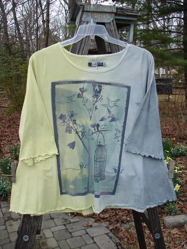 Barclay Three Quarter A Line Tee Garden Friend Sunshine Size 0 with bird and tree print, displayed on a hanger, featuring a rounded neckline and flat edgings, made from mid-weight organic cotton.