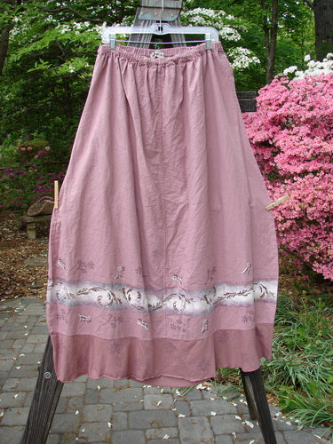 Barclay Linen Duet Skirt Falling Fern Dried Rose Size 2, featuring a full elastic waistline and widening bell shape, hanging on a clothesline outside.