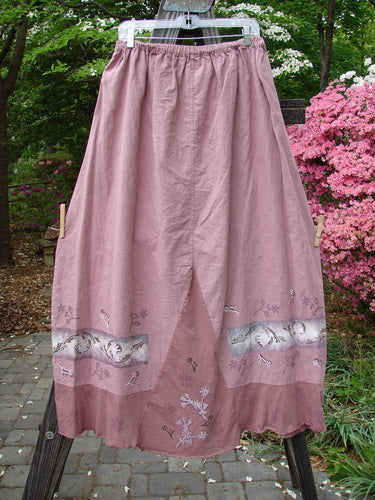 Barclay Linen Duet Skirt Falling Fern Dried Rose Size 2, featuring a full elastic waistline, widening bell shape, sectional panels, and a unique floral pattern, displayed hanging outdoors.