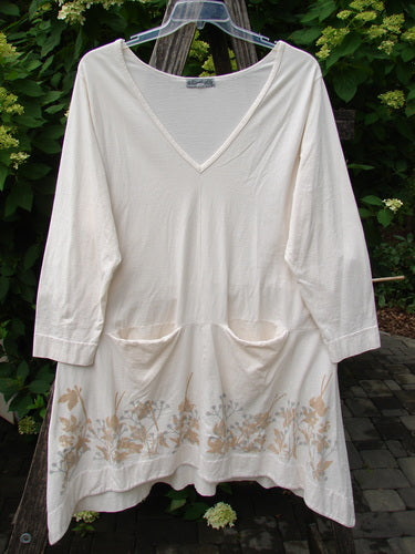 Barclay Deep V Neck Rear Banded Pocket Tunic Morning Garden Dew Size 1, featuring three-quarter sleeves, V-neck, hip-level pockets, and floral print along the hem, hanging outdoors, reflecting BlueFishFinder's vintage, individualistic style.