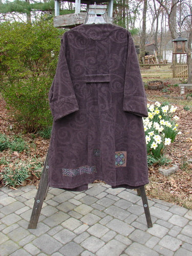 2000 Patched Upholstery Diwmach Coat Celtic Time Aubergine Size 0, featuring a scalloped neckline, vintage buttons, belled sleeves, colorful patches, large front pocket, and pleated rear, displayed on a rack.