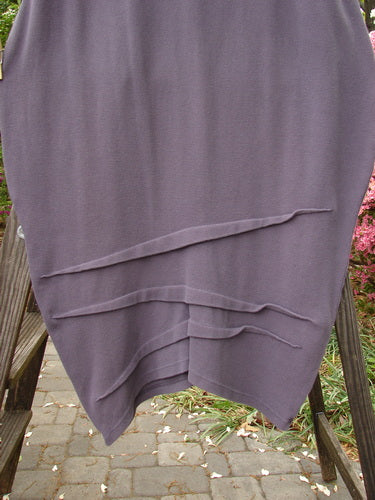 2000 NWT Thermal Awen Skirt with Larger Elastic Waistline on a wooden stand, showcasing its textured diagonal hemline and unique folds.