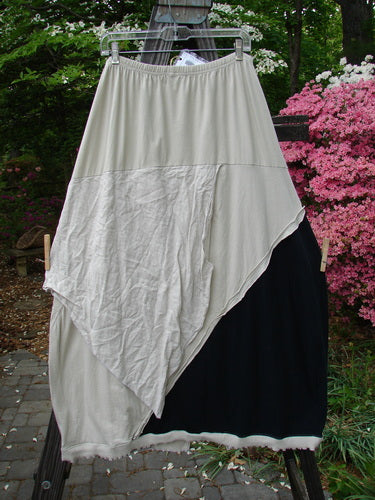 Barclay NWT Mixed Media Swatch Skirt Unpainted Black and Wash Size 2 hanging on a clothesline, showcasing its layered upper, sectional panels, and full elastic waistline against an outdoor backdrop.