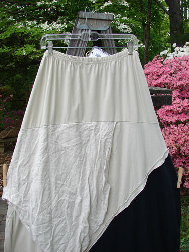 Barclay NWT Mixed Media Swatch Skirt in Black Wash, displayed outdoors on a hanger, showcasing its layered textures, directional swatches, and full elastic waistline.