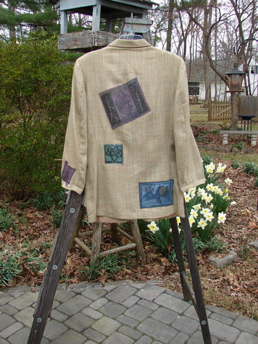 1994 Patched Blazer Elements Grass Wheat Tweed OSFA on a stand, featuring nature-themed patches, square shoulder pads, a handkerchief slit pocket, and a three-button closure, displayed outdoors.
