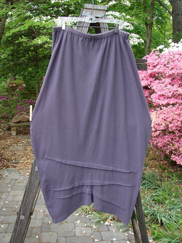 2000 Thermal Awen Skirt Larger Elastic Unpainted Eggplant Size 2 hanging outdoors on a clothesline, showcasing its full elastic waistband and unique textured hemline with directional fabric folds.