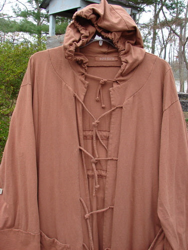 1998 Albion Hooded Jacket Coat Harvest Time Rockwood OSFA displayed on a swinger, showcasing its wide lower sleeves, triangular front pockets, and cozy hood, perfect for expressing individual style.