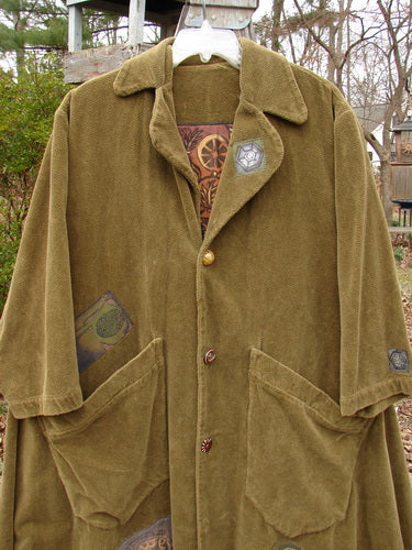 1998 Patched Tapestry Coat Forest Path Glazed Tile OSFA displayed on a hanger, showcasing a heavy, richly textured cotton fabric with swirl patterns, angular pockets, vintage buttons, and a stand-up collar.