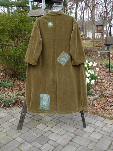 1998 Patched Tapestry Coat Forest Path Glazed Tile OSFA displayed on a rack, showcasing its luxurious texture, vintage buttons, angular pockets, and distinctive patches in a mixed forest path theme.