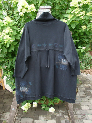 Barclay Interlock Turtleneck Pullover Tunic Top Celtic Night Black Size 2 features a loose fit with a high collar, three-quarter sleeves, decorative motifs, and a drawstring waist, hanging outdoors.