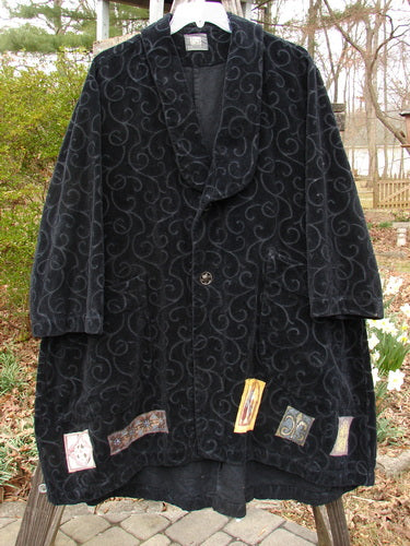 1999 Patched Poet's Coat Holiday Time Black Size 0, featuring a textured vine pattern, colorful patched hem, oversized buttons, diagonal front pockets, folded collar, and varying hemline.