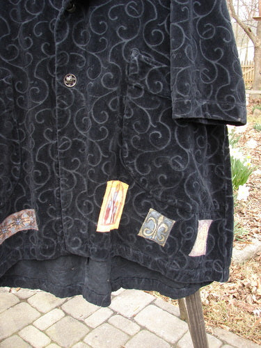 1999 Patched Poet's Coat Holiday Time Black Size 0, featuring a vine-patterned pile, oversized button closures, colorful patched hem, diagonal front pockets, and a folded collar.