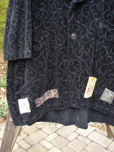 1999 Patched Poet's Coat Holiday Time Black Size 0, featuring a vine-patterned design, oversized vintage button closures, folded collar, diagonal pockets, and a varying hemline in richly textured cotton tapestry.
