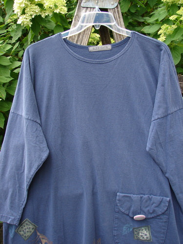 1996 Long Sleeved Pop Top Fall Leaves Niagara OSFA, featuring a rounded hemline, scooped neckline, oversized front pocket with button, and rear drawcord back, elegantly displayed against a leafy plant backdrop.
