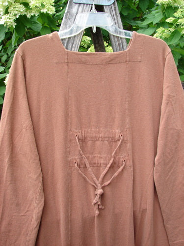 1998 Mandolin Dress Lucky Horseshoe Rockwood Size 2, featuring a plain, long-sleeved tunic style with a square neckline and laced-up back detail, hanging on a clear plastic hanger.