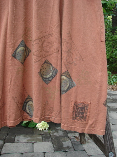 1998 Mandolin Dress Lucky Horseshoe Rockwood Size 2, draped over a wooden frame, showcases a rust-brown fabric with diamond motifs and circular designs, featuring the signature Blu Fish label near the hem.