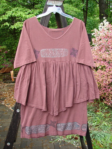1993 Picnic Dress Fern Boysenberry OSFA on a wooden rack, featuring a gently rounded V neckline, flounce detailing, and fern and flower theme paint with a vintage signature patch.
