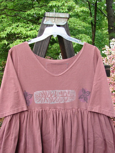 1993 Picnic Dress Fern Boysenberry OSFA displayed on a hanger, featuring a rounded V neckline, continuous flounce, straight upper waist seam, and pencil straight shorter under piece with a fern and flower theme.