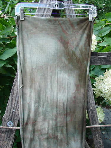 Barclay Diagonal Sectional Scarf Wrap Unpainted Mottled Night Storm OSFA, a lightweight, hand-dyed scarf with curly edges and diagonal seams, hanging on a clear plastic hanger outdoors.
