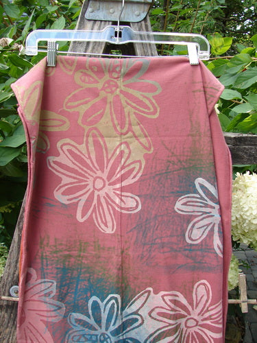 Barclay NWT Wide Sectional Scarf Daisy Desert Rose OSFA displayed outdoors, featuring large daisy prints in cream, white, and pale blue on dusty pink fabric. Hangs on clear hanger against garden backdrop.