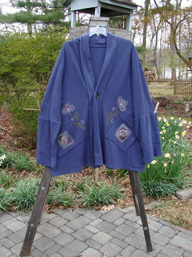 1995 Reprocessed Deco Jacket Greyhound Royal Orchid OSFA displayed on a rack, showcasing its dense, nubby cotton texture, drop dolman shoulders, deep V neckline, and oversized painted pockets with a greyhound theme.
