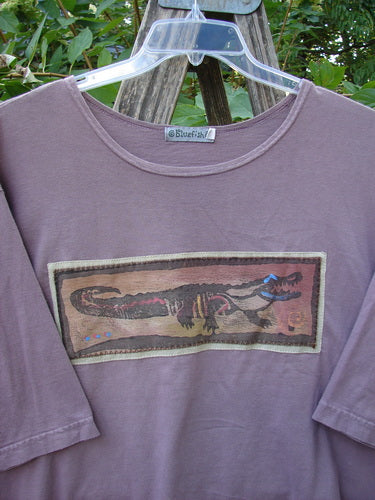 Barclay PMU Patched Short Sleeved Crop A Line Tee Dark Mallow Size 2, featuring a stylized alligator patch on the chest, hangs on a wooden frame, embodying Bluefishfinder.com's vintage upcycled style.