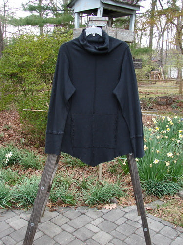 Barclay Lightweight Thermal Cowl Neck Roo Tunic Unpainted Black Size 1 displayed on a wooden stand, showcasing its narrowing shape, curly edgings, ribbed waffle cuffs, and lower drop kangaroo pocket.
