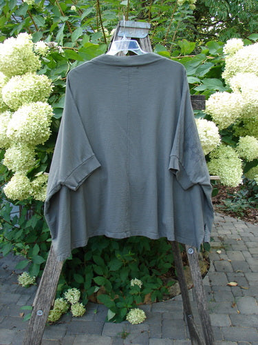 Barclay Slub Dolman Shirttail Pocket Jacket Fern Green Army Size 0 displayed on a wooden ladder, showcasing its wide sleeves, dolman seamless shoulders, thickly ribbed collar, and unique shirttail hemline.