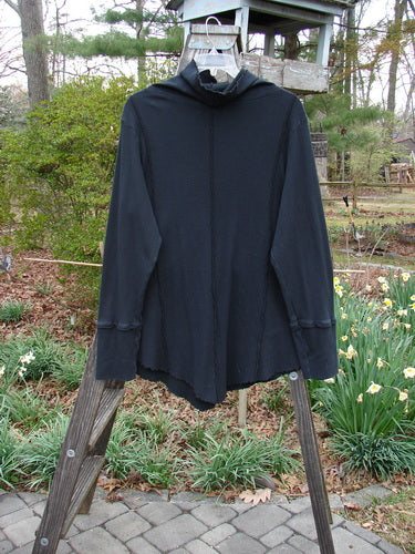 Barclay Light Weight Thermal Cowl Neck Roo Tunic Unpainted Black Size 1 displayed on a wooden stand, showcasing exterior stitchery, ribbed waffle cuffs, and a lower drop kangaroo tunnel pocket.