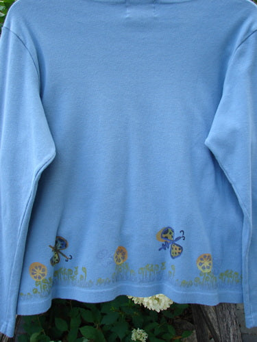 1999 Round Neck Rib Top Butterfly Blue Stone Size 2, featuring a whimsical grass and toadstool mushroom hem design, hangs outdoors, showcasing its slightly cropped, boxy shape and flared hemline.