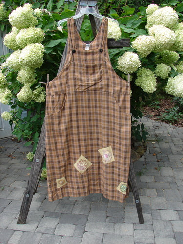 1999 Patched Overall Jumper Mixed Far Eastern Gold Plaid Size 2 displayed outdoors on a wooden easel, features a sleeveless plaid design, decorative patches, and a buttoned bib front.