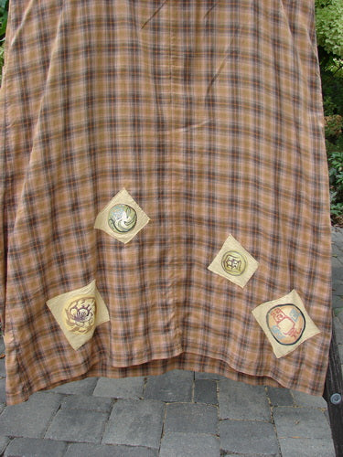 1999 Patched Overall Jumper Mixed Far Eastern Gold Plaid Size 2 hangs outdoors, showcasing a distinctive plaid pattern with four decorative patches, including a lotus motif and matryoshka illustration, emphasizing its vintage allure.