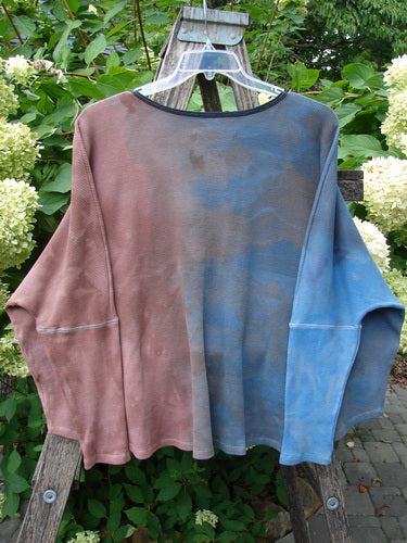 Barclay NWT Thermal Crop Top Finch Mottled Bibbi Blue OSFA draped over a wooden ladder, showcasing its unique split color design, waffle texture, rounded neckline, and drop shoulders.