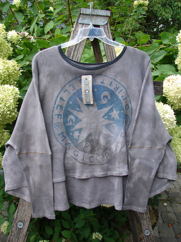 Barclay NWT Thermal Crop Top Belief Magic Mottled Spirit OSFA, featuring bell sleeves, a scooped neckline, and faded blue graphic, displayed on a hanger against a natural backdrop.