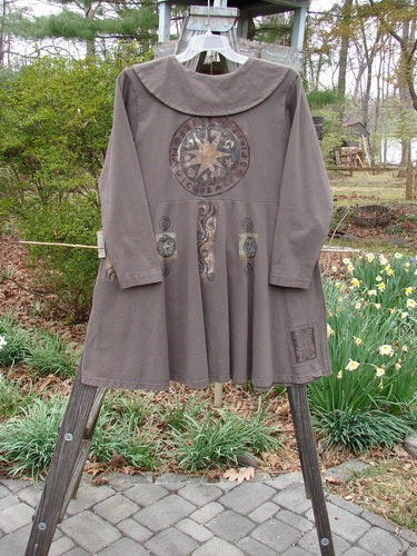 1994 Poppy Dress Belief Spirit Magic Humus Size 1 displayed on a wooden rack, showcasing its sweet rounded collar, empire waistline, and vintage pressed paper buttons.