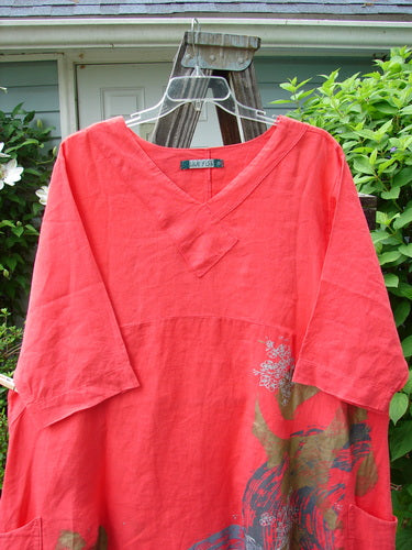 Barclay Linen Cross Over Dress Golden Lookout Geranium Size 2 displayed on a hanger, showcasing its V neckline, drop shoulders, empire waist seam, and double side pockets.