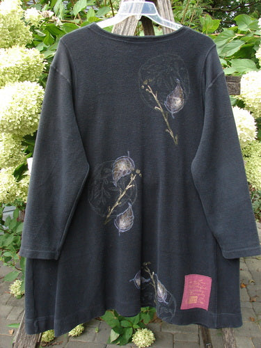 1998 Heavy Berber Kindlewood Tunic Leaf Sprig Black OSFA features hand-painted floral motifs, pink fabric patch, cozy long sleeves, and toggle button accents, hung against a lush garden backdrop.